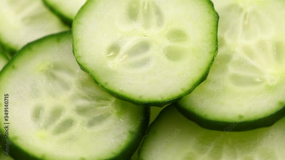 Cucumber, sliced pieces of green cucumber stacked on a hill rotate, spinning slowly in a circle, close up. Cucumber, sliced pieces of green cucumber stacked on a hill rotate, spinning slowly in a circle, close up.