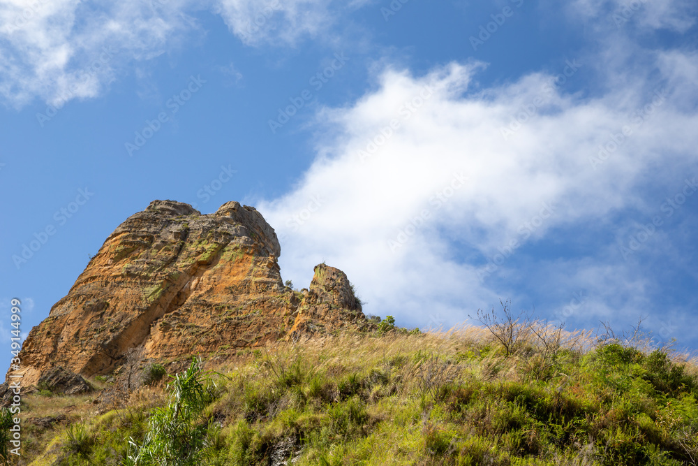 Mountains covered with plants and a blue sky with small clouds