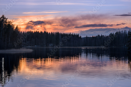 Scenic lake landscape with tranquility mood, sunset and beautiful reflections at spring evening in Finland
