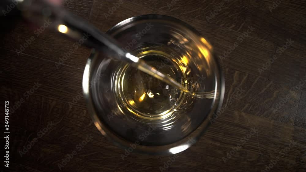 pouring whiskey to the glass in slowmotion