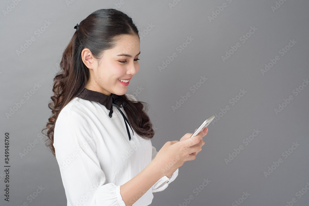 Portrait of Beautiful Business woman is using cellphone in studio Portrait of Beautiful Business woman is using cellphone in studio