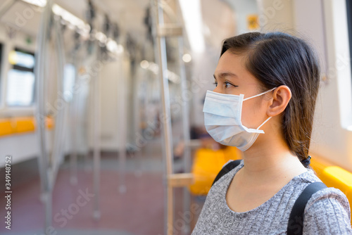 Young Asian woman with mask for protection from corona virus outbreak sitting inside the train