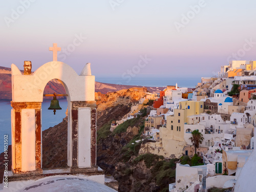 Church bell and Santorini island view on cave houses. Cyclades, Greece.