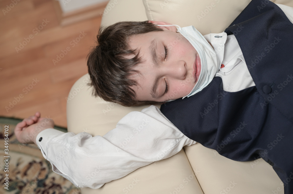 coronavirus covid-19 epidemic outbreak quarantine concept of small boy in medical mask lying at home being sick with high temperature coronavirus covid-19 epidemic outbreak quarantine concept of small boy in medical mask lying at home being sick with high temperature