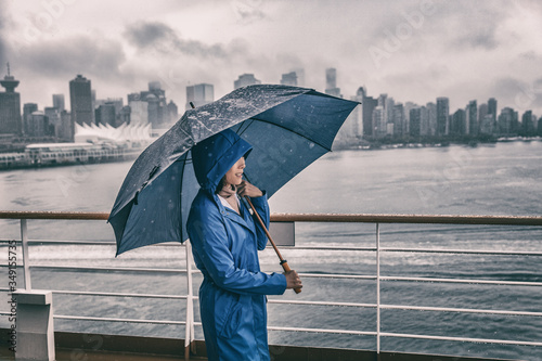 Картината върху платно Rain storm Asian woman outside with umbrella watching Vancouver city on cruise ship background