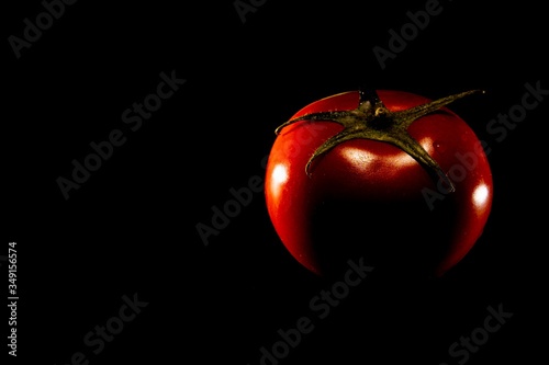 oranged red tomato on black background