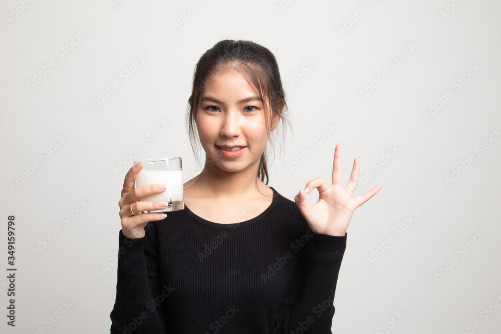 Healthy Asian woman drinking a glass of milk show OK sign. Healthy Asian woman drinking a glass of milk show OK sign.