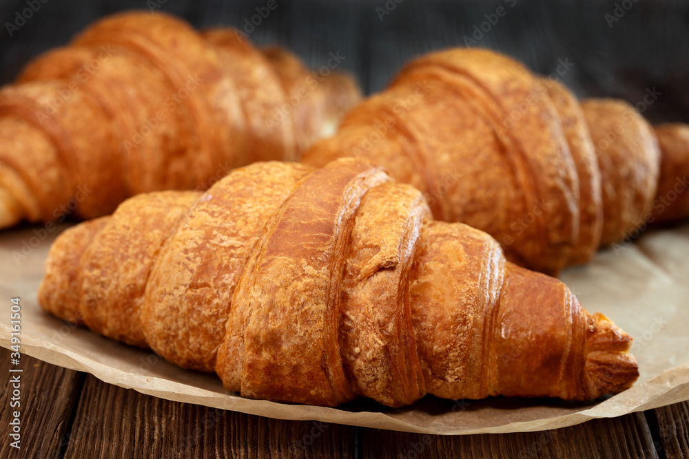 set of fresh baked croissants on wooden table set of fresh baked croissants on wooden table