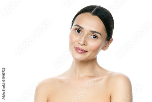 Beautiful smiling woman with clean skin, natural make-up, and white teeth on white background