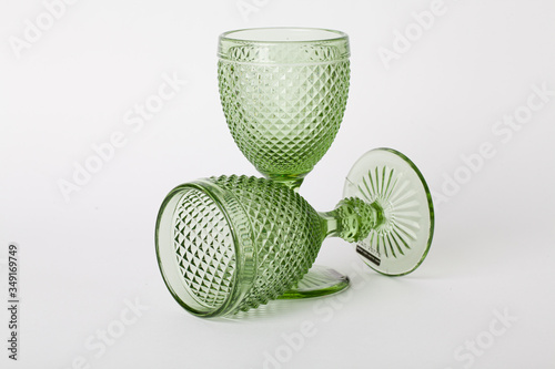 two empty glasses of green glass on a stem on a white background