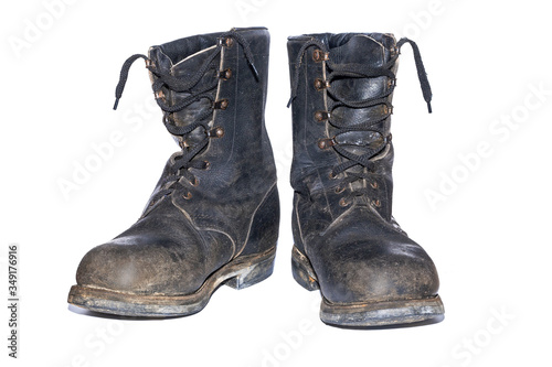 old soldier's boots worn with scratches and untied shoelaces. Old shabby leather boots isolated on white background. old leather military boots isolated on white background.