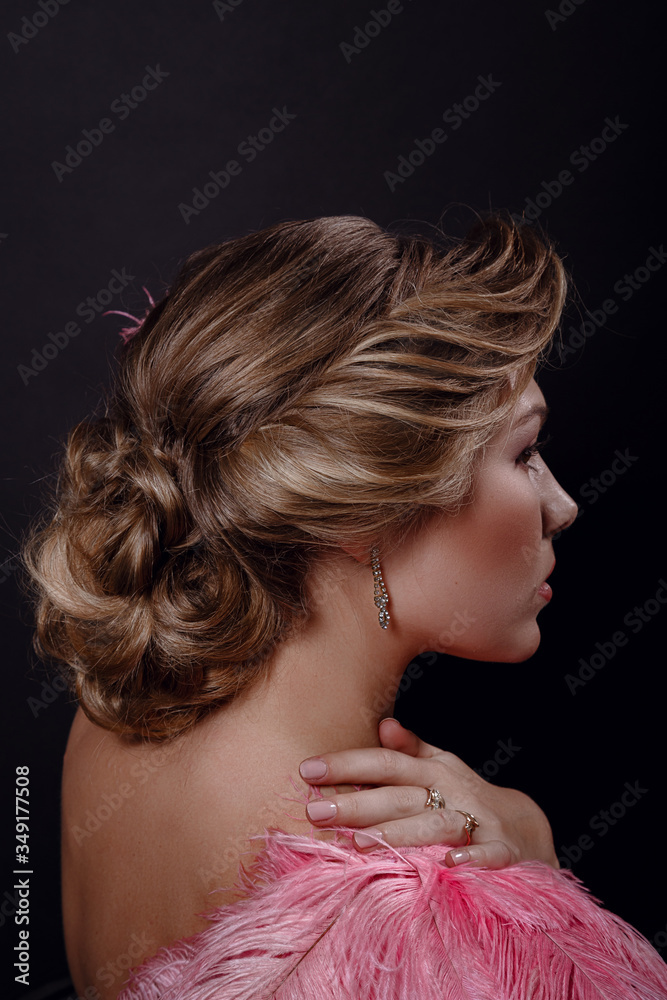 Naklejka premium The beautiful girl in a beautiful pink dress on black background