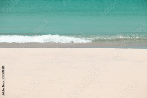 white sandy beach and turquoise sea water on sunny day