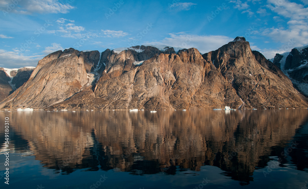 Mountains and icebergs reflected in calm water, O Fjord, Greenland