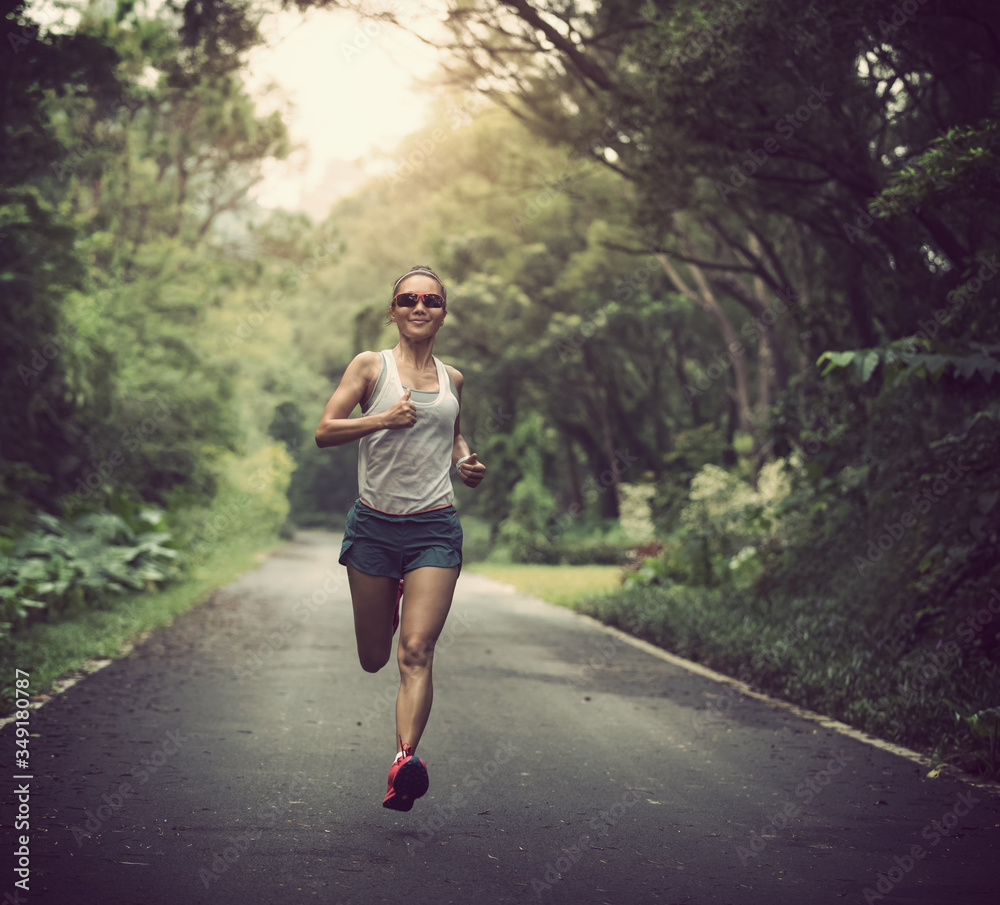Female runner running at summer park trail . Healthy fitness woman jogging outdoors. Female runner running at summer park trail . Healthy fitness woman jogging outdoors.