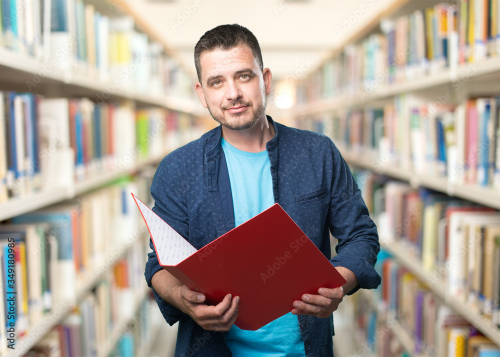 Young man wearing a blue outfit. Holding a red folder. Young man wearing a blue outfit. Holding a red folder.