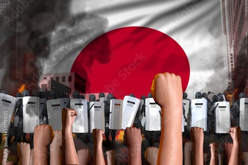 Φωτογραφία Protest in Japan - police guards stand against the protesting crowd on flag back