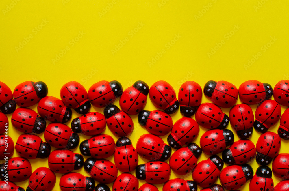 decorative wooden ladybugs on yellow background with copy space. Ladybug pattern. decorative wooden ladybugs on yellow background with copy space. Ladybug pattern.