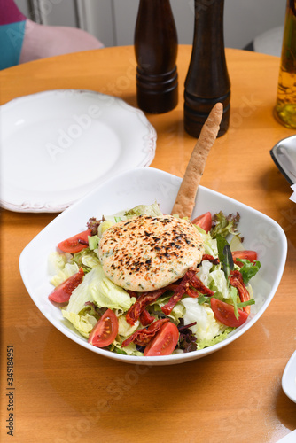 healthy and delicious salad with goat cheese, lots of greens photo