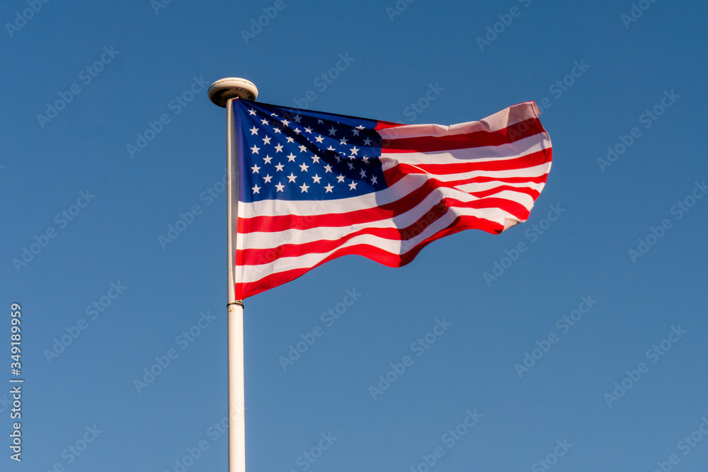 The starry flag of the United States of America (USA) on the blue sky background