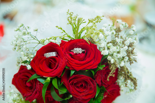 There are drops of water on the roses . Wedding bouquet of red flowers.