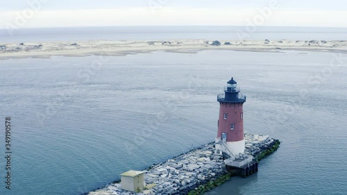 Old Red Breakwater Light House Cape Henlopen Delaware Bay United States and Atlantic Ocean on Overcast Spring Day Aerial Reveal photo