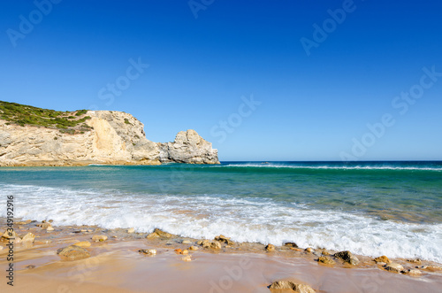 View of the limestone cliffs and Atlantic ocean. Ravine Beach (Praia do Barranco) - wild beach and popular surfing spot in Algarve. Sagres (Vila do Bispo), District Faro, Southern Portugal.