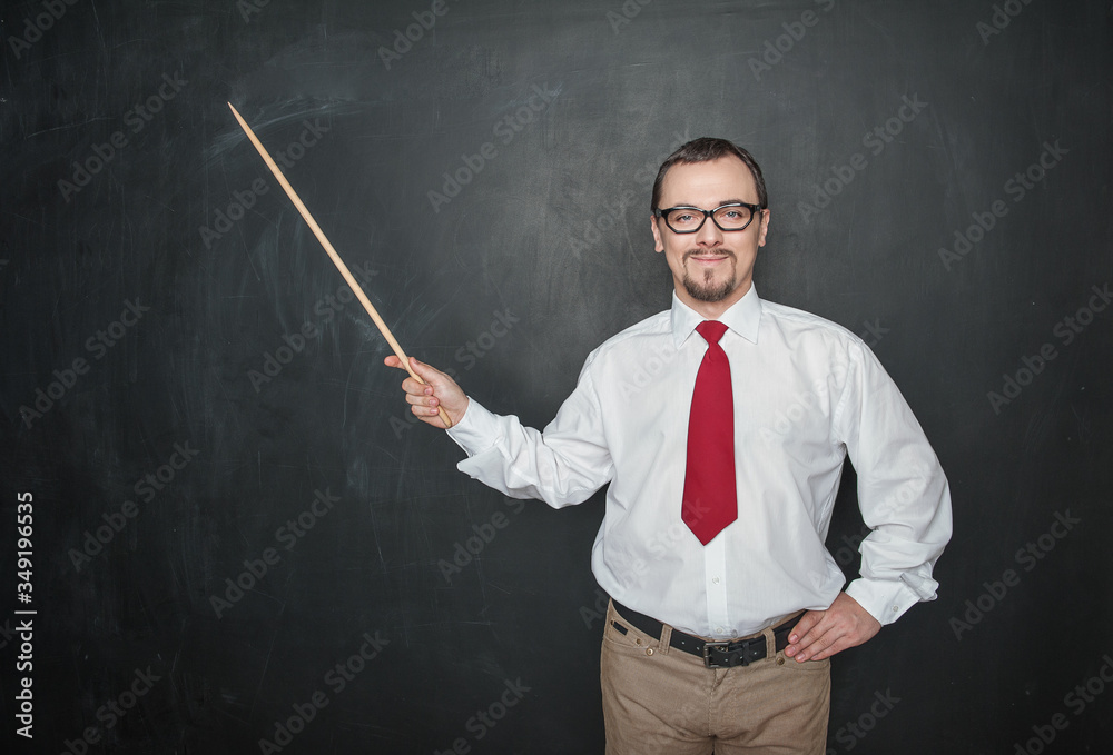 Smiling teacher man retro style with pointer on blackboard background Smiling teacher man retro style with pointer on blackboard background