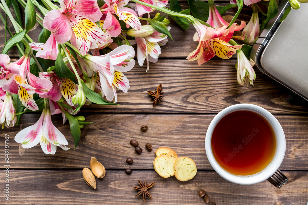 
cup of tea on the table. flowers, tea cookies.