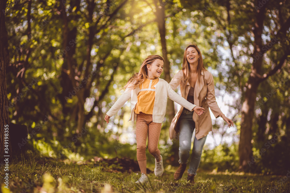 Fototapeta premium This is a perfect and fun day. Mother spending time with her daughter outside. Focus is on foreground.