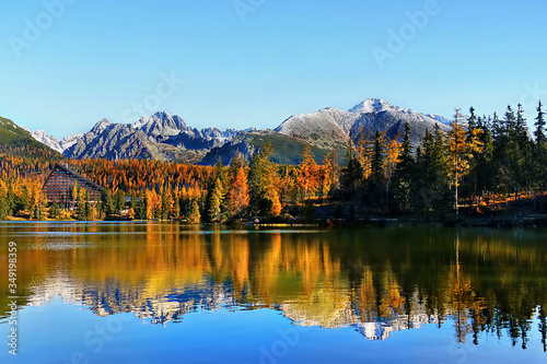 Sunrise view on mountains and lake with reflection in autumn landscape