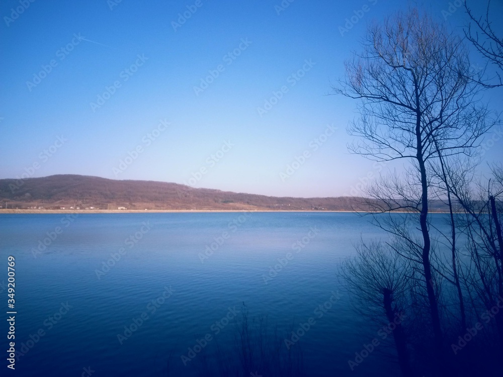 peaceful water close to the forest in spring season. calm lake reflecting clouds peaceful water close to the forest in spring season. calm lake reflecting clouds