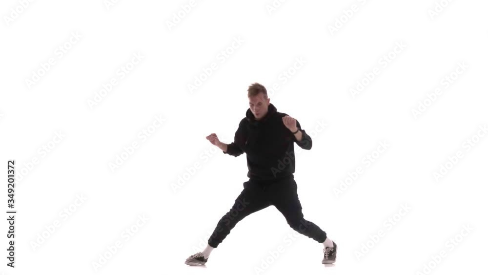 young handsome man in black tracksuit vigorously dancing hip hop, freestyle, street dance, performs complex movements, isolated young handsome man in black tracksuit vigorously dancing hip hop, freestyle, street dance, performs complex movements, isolated