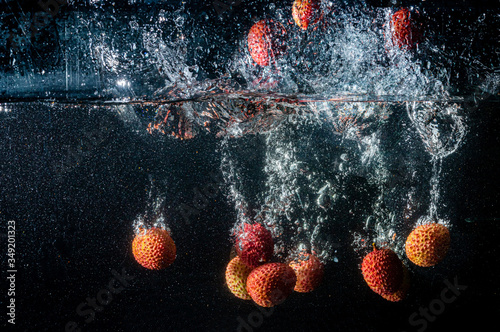 Wallpaper Mural Lychee berries fall into the water scattering a lot of splashes and drops. Torontodigital.ca