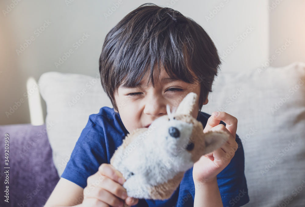Healthy kid portrait playing with dog toy looking at camera with funny face, candid shot cute child boy relaxing stay at home during covid lock down.Positive children concept,Social distancing Healthy kid portrait playing with dog toy looking at camera with funny face, candid shot cute child boy relaxing stay at home during covid lock down.Positive children concept,Social distancing