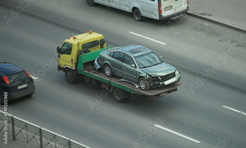A tow truck in the city carries a broken car after the accident