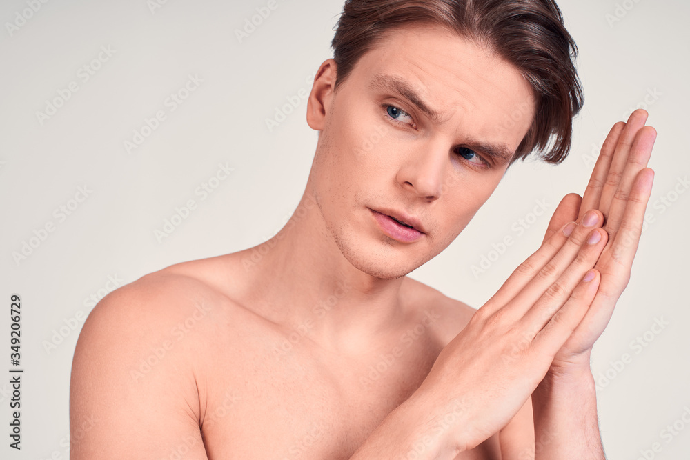 Sexy serious naked guy rubs his palms. Sexy serious naked guy rubs his palms.