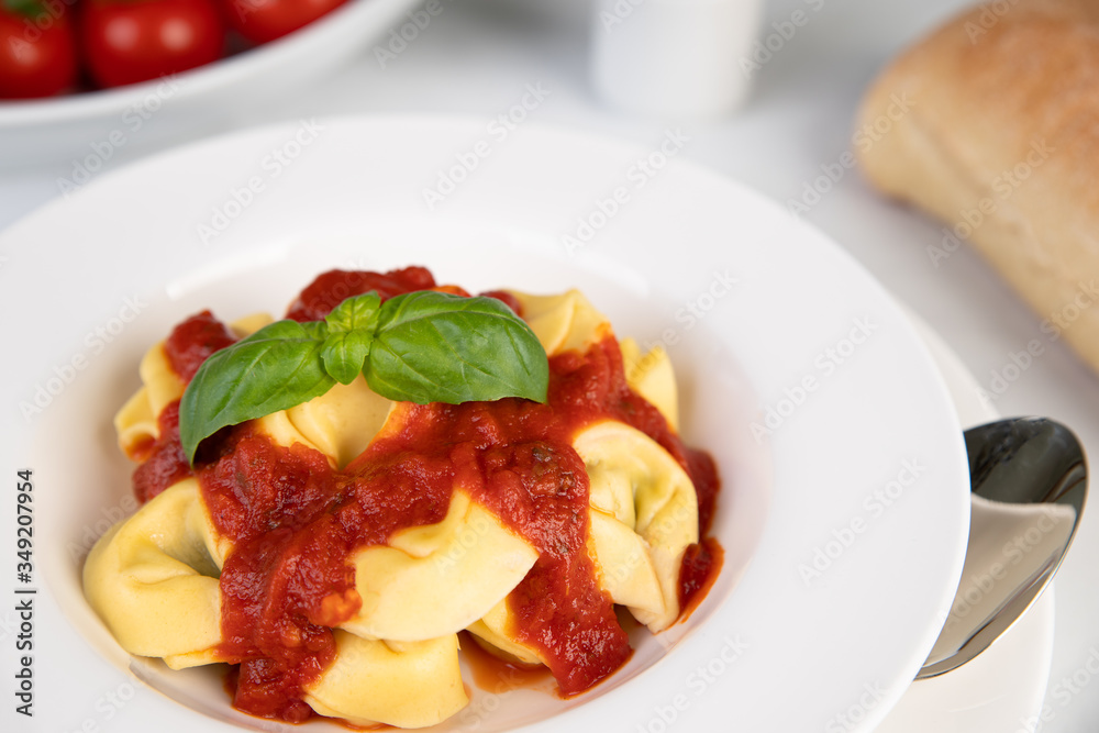 Frische Tortelini mit Tomatensoße und Basilikum Frische Tortelini mit Tomatensoße und Basilikum
