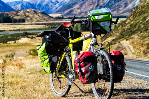 ATHUR'S PASS, NEW ZEALAND - MARCH 5, 2017: Heavy loaded bicycle with panniers and bags in Arthur's Pass National Park - popular tourist and cyclist destination in New Zealand. South Island photo