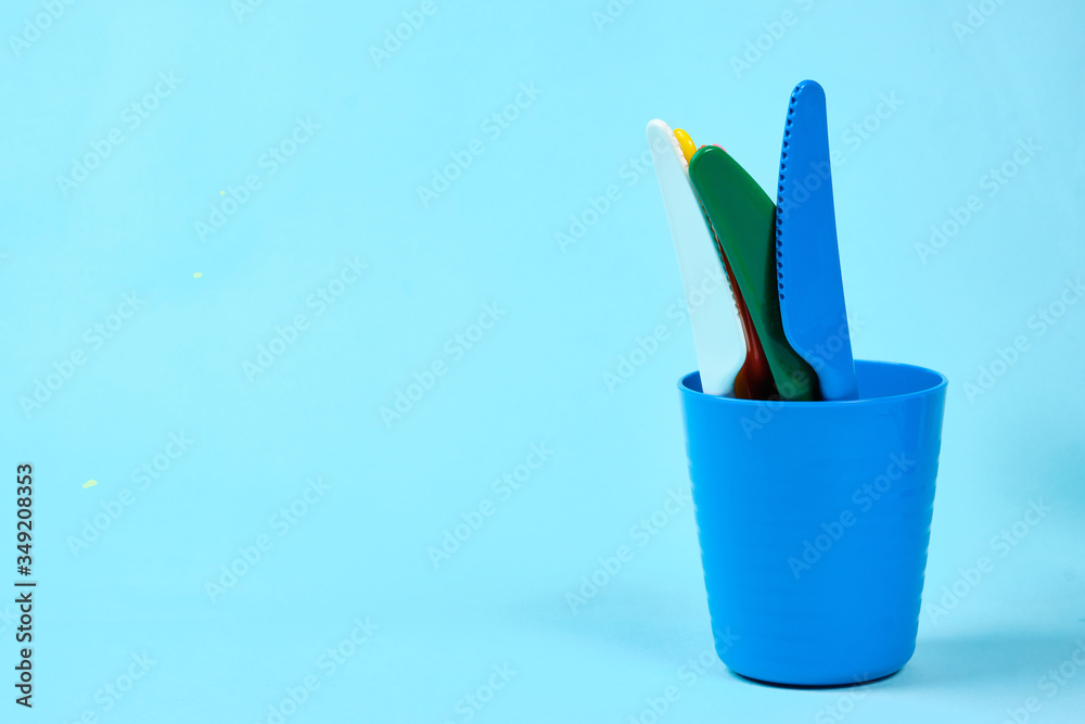 Multicolored plastic dishes on a blue background. The concept of environmental pollution by plastic, ecolog place for text, flat lay Multicolored plastic dishes on a blue background. The concept of environmental pollution by plastic, ecolog place for text, flat lay