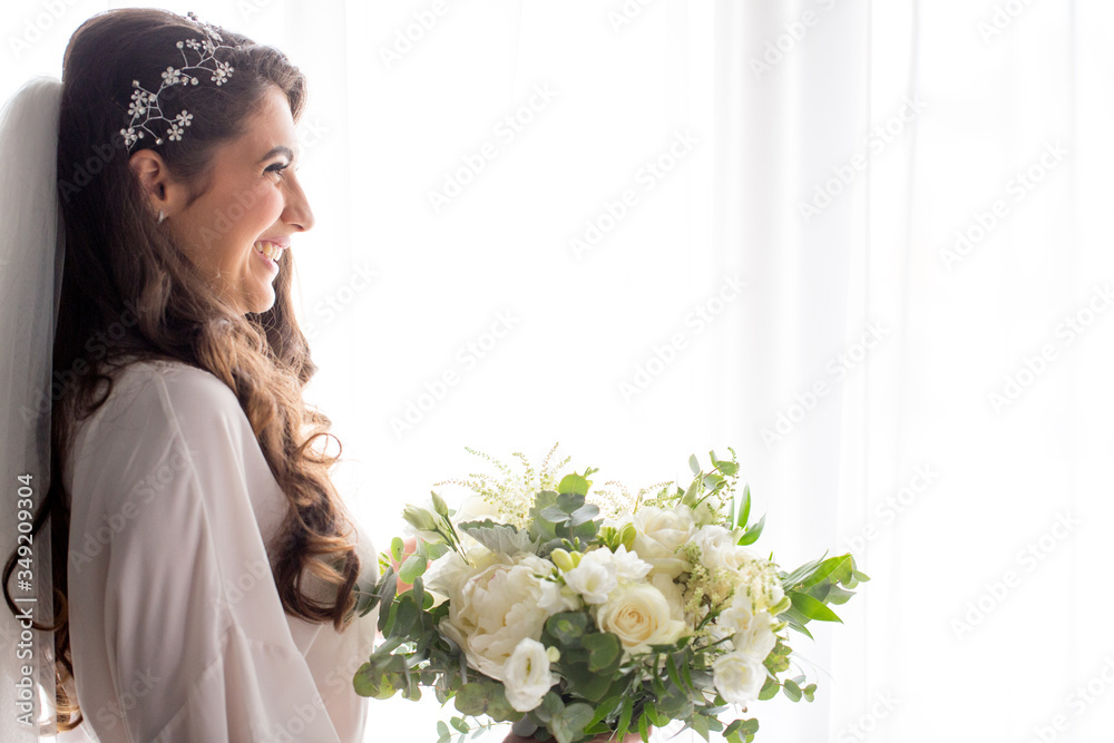 beautiful girl posing in white bridal robe with bouquet of flowers in hand beautiful girl posing in white bridal robe with bouquet of flowers in hand