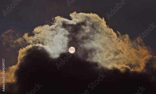 solar disk filtred trough clouds. shining sun on summer sky photo