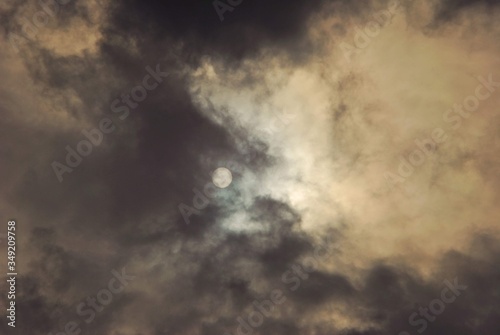 solar disk filtred trough clouds. shining sun on summer sky photo