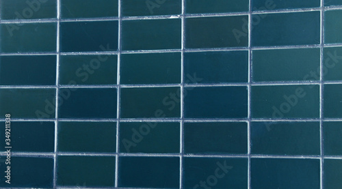 background of dark blue rectangular ceramic tiles. blue tile in shape of a rectangle. background of regular tiles without ornament. photograph of old simple soviet tiles in modern style.