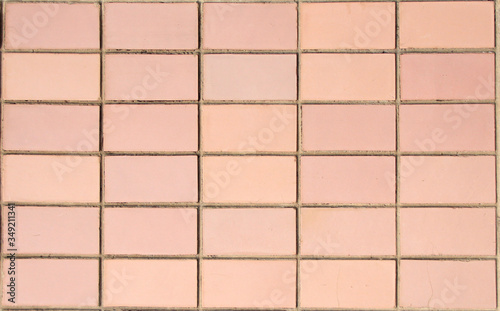 background of pink rectangular ceramic tiles. light pink tiles in shape of a rectangle. background of regular tiles without ornament