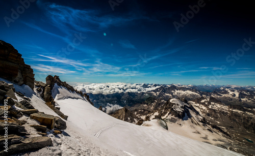 Stunning view of the Alps from above the clouds in summer, near the summit of Gran Paradiso, Italian Alps