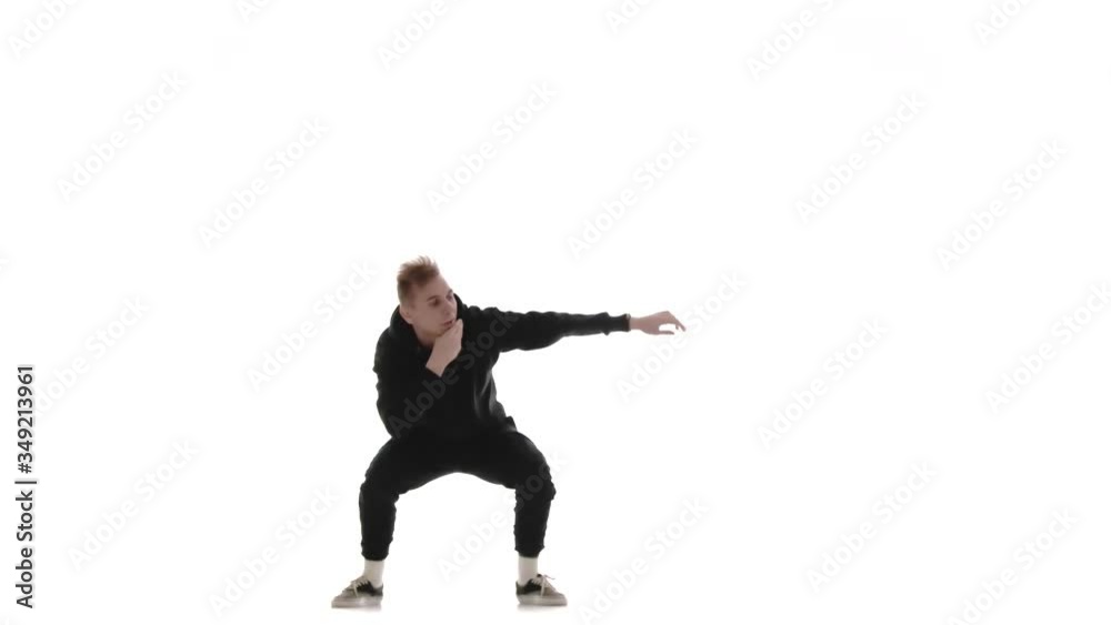 young handsome man in black tracksuit vigorously dancing hip hop, freestyle, street dance, performs complex movements, isolated young handsome man in black tracksuit vigorously dancing hip hop, freestyle, street dance, performs complex movements, isolated