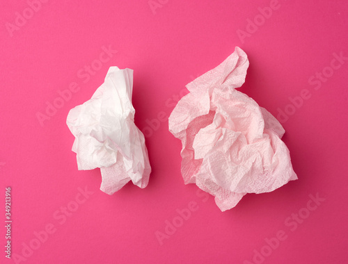 crumpled white paper disposable napkins on a pink background
