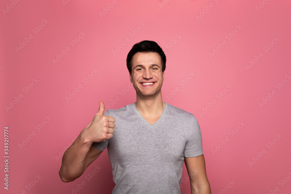 A-Okay! Close-up photo of a happy man in everyday outfit, who is looking in the camera with a big smile and showing thumbs up.