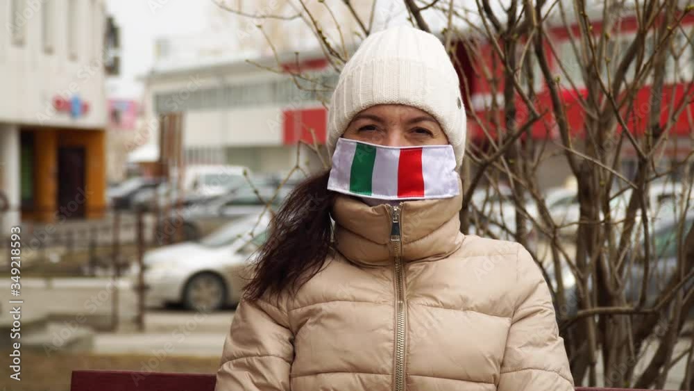 Virus and disease prevention concept. Portrait of a woman wearing a protective medical mask with an italian flag. Protection against coronavirus and other diseases. Virus and disease prevention concept. Portrait of a woman wearing a protective medical mask with an italian flag. Protection against coronavirus and other diseases.